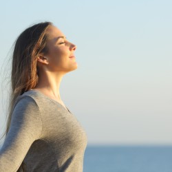 Woman breaths fresh air on the beach